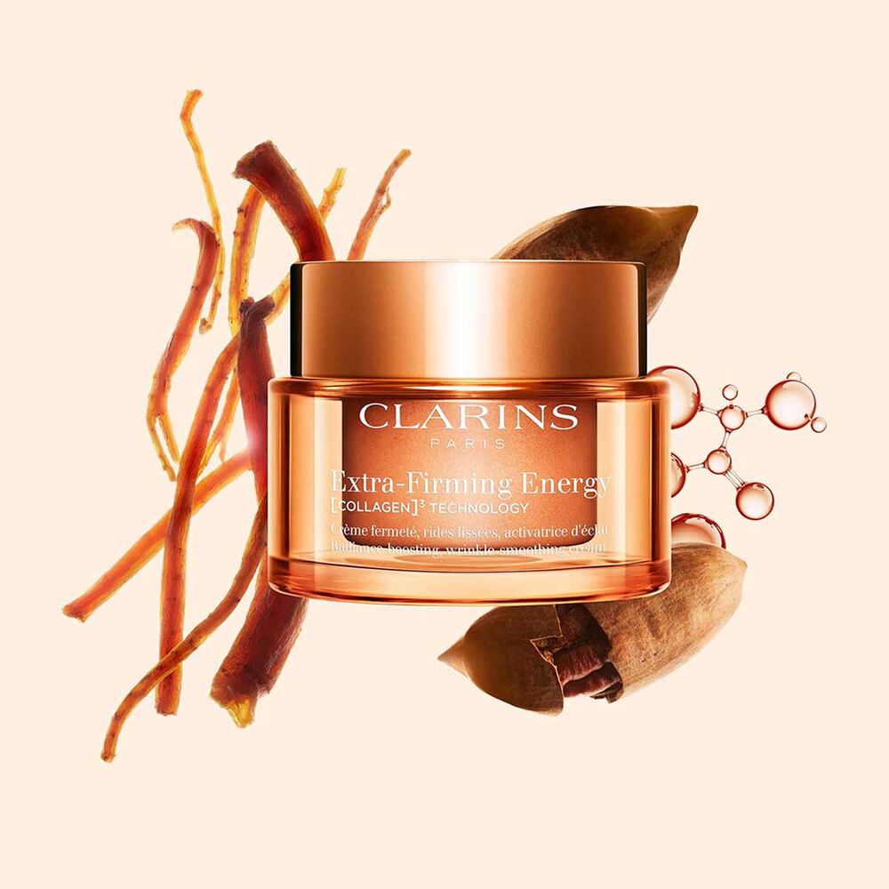 Foto de la recarga de la crema Extra-Firming Energy de Clarins junto a ginseng rojo, mol&eacute;cula de col&aacute;geno y Mitracarpus sobre fondo beige.