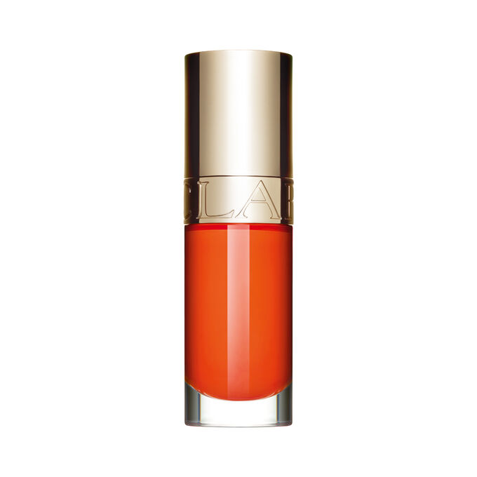 Foto del aceite labial naranja de Clarins delante de una flor de rosa mosqueta con un fondo blanco