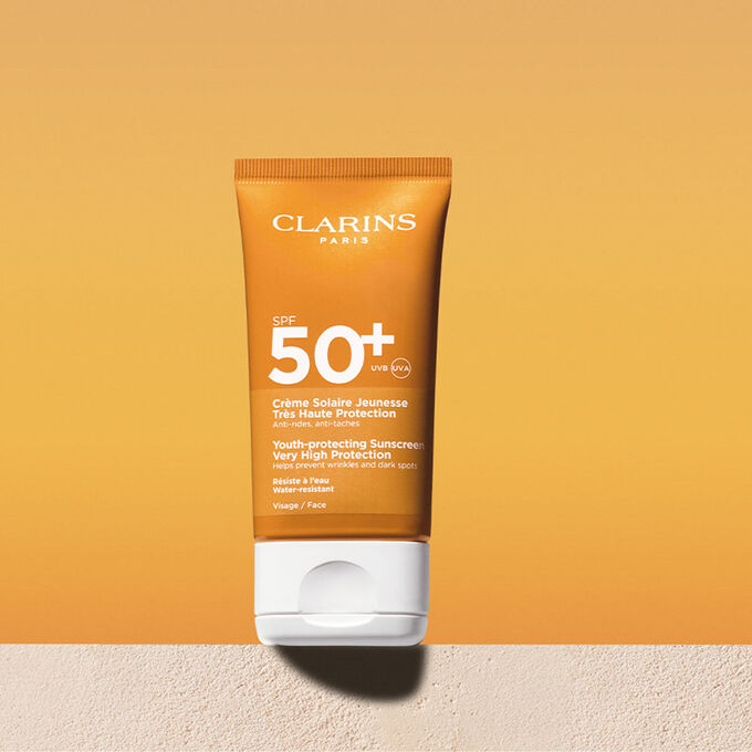 Foto del tubo de crema solar facial factor&nbsp;50 con un mensaje que anuncia que Clarins se compromete con la protecci&oacute;n del medio ambiente