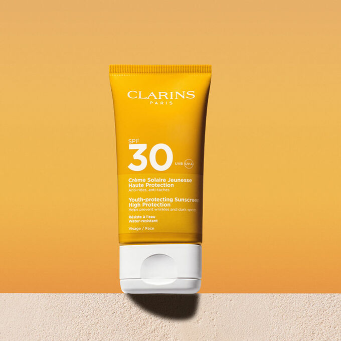 Foto del tubo de crema solar facial factor&nbsp;30 con un mensaje que anuncia que Clarins se compromete con la protecci&oacute;n del medio ambiente
