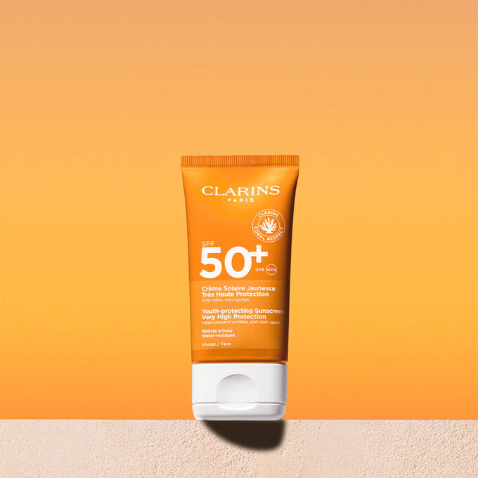 Foto del tubo de crema solar facial factor 50 con un mensaje que anuncia que Clarins se compromete con la protección del medio ambiente