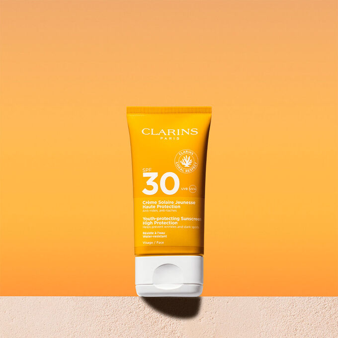 Foto del tubo de crema solar facial factor 30 con un mensaje que anuncia que Clarins se compromete con la protección del medio ambiente
