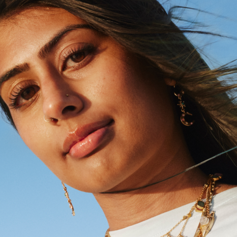 Primer plano de una mujer joven con un cabello largo y oscuro soplado por el viento