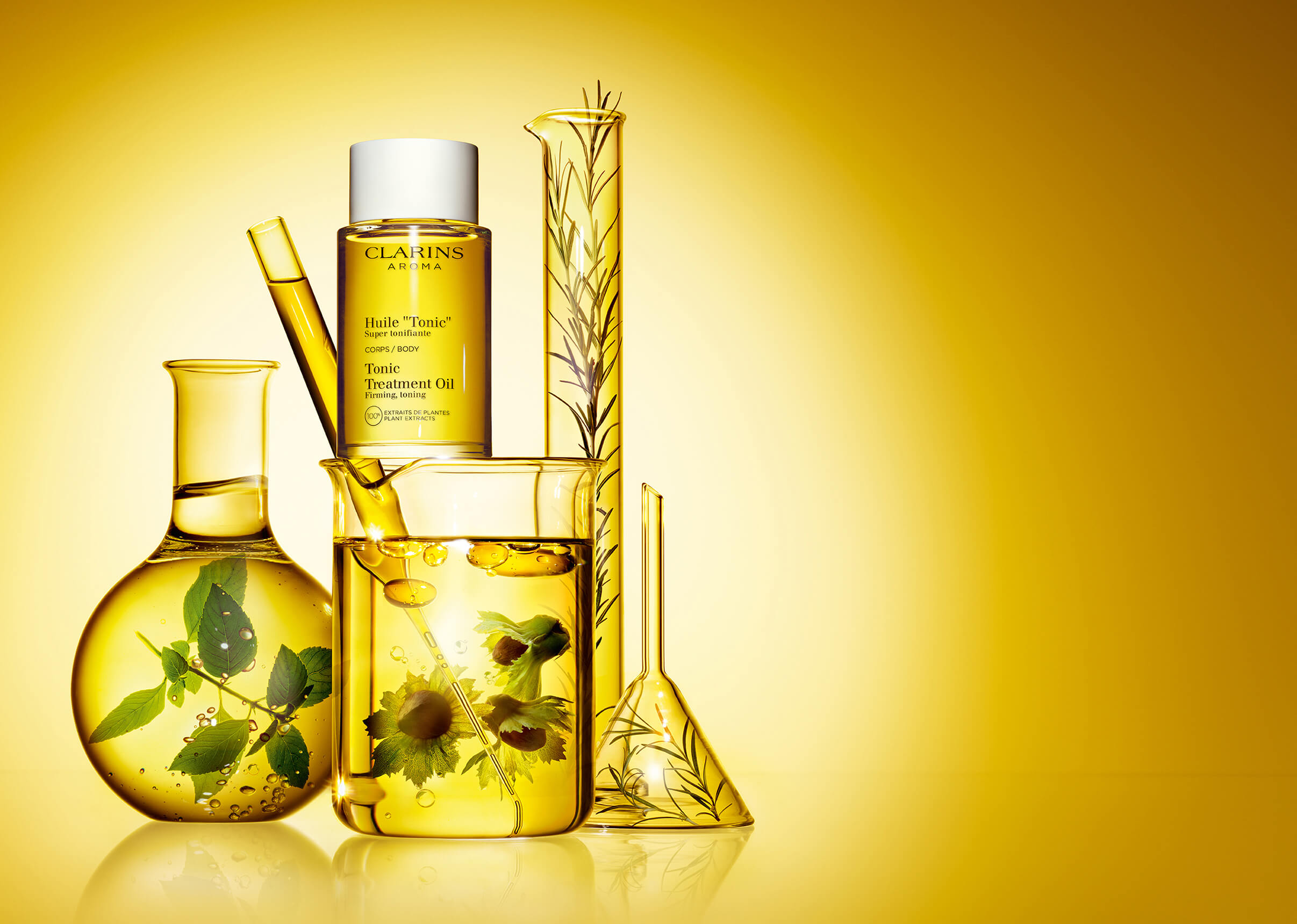 Foto del envase de Aceite 'Tonic' junto con vasos de laboratorio