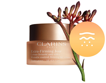 Foto del envase de Extra-Firming Jour con el principal ingrediente al lado, la flor de canguro