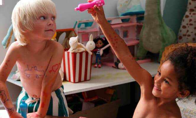 Un niño y una niña jugando en un cuarto.